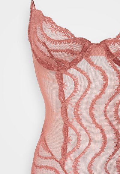 Mežģīņu bodijs mīkstā rozā krāsā ar viļņainiem izšūtiem rakstiem. Caurspīdīgs tīkls audums ar smalkām apdares detaļām uz krūzītēm un malām.