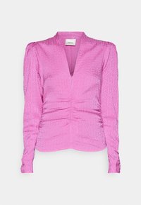 Vaaleanpunainen pitkähihainen pusero, jossa on v-kaula-aukko ja hienovaraiset, tekstuurilliset kuviot sekä laskokset vyötäröllä ja hihoissa.