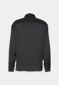 Zwarte lange mouwen shirt gemaakt van glad, glanzend stof. Voorzien van een klassieke kraag en knoopmanchetten. Eenvoudig en onopvallend ontwerp aan de achterkant.