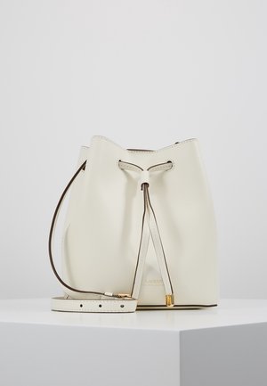 Biała skórzana torebka typu bucket z regulowanym paskiem, zamknięciem na ściągacz i złotymi akcentami, na białej powierzchni na jednolitym tle.