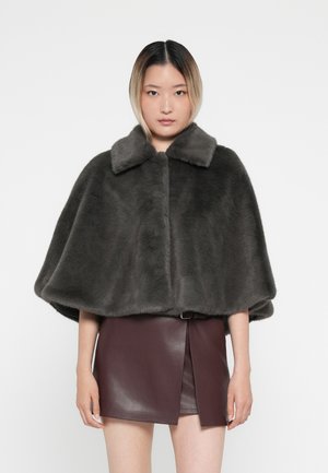 Donkergrijze nepbontcape met een kraagnek, met een zachte textuur en een wijdvallend ontwerp. Gepaard met een bordeauxrood leren rok.