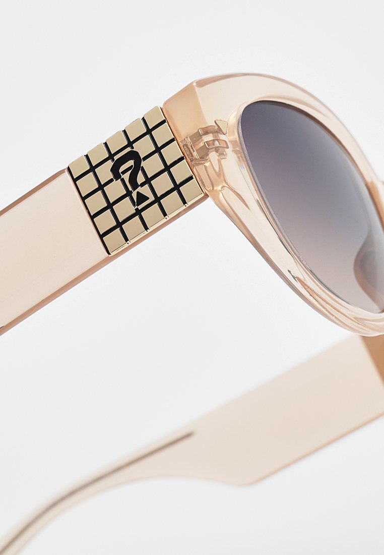 Sonnenbrille mit einem hellrosa transparenten Rahmen, dunklen Gläsern, quadratischen schwarz-goldenen Mustern an den Schläfen und einem eleganten Design.