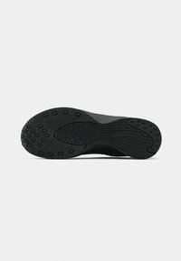 Talpa de pantof sport negru, cu cauciuc texturat, având un model în valuri și diverse protuberanțe circulare pentru aderență. Design plat și larg.