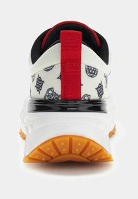 Baskets blanches avec un arrière à motif, un tirette rouge, des détails noirs et une semelle extérieure en caoutchouc orange. Elles présentent un matériau en mesh et des accents texturés.