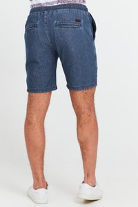 Scurți din denim într-o nuanță albastră închisă, cu un elastic la talie, două buzunare pe spate și o cusătură contrastantă. Completați cu adidași albi.