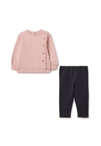 Sweatshirt rose avec des détails en volants et des boutons en bois, associé à des leggings en stretch bleu marine. Les deux sont fabriqués à partir de tissu doux et confortable.