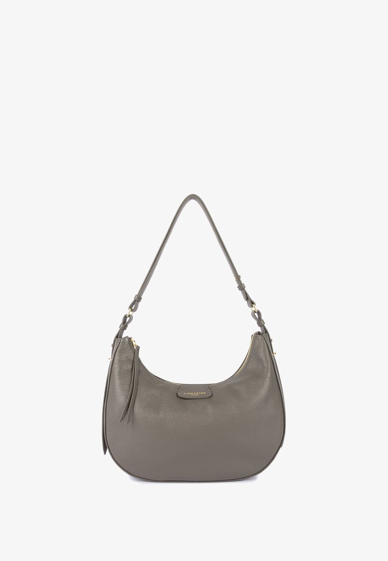 Sac à main en cuir gris avec une forme courbe, une seule sangle, quincaillerie dorée et un compartiment zippé. Il présente un accent de pompon.