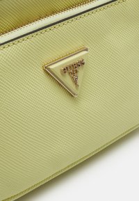 Guess NOELLE POUCH CROSSBODY - Keresztpántos táska - pale yellow