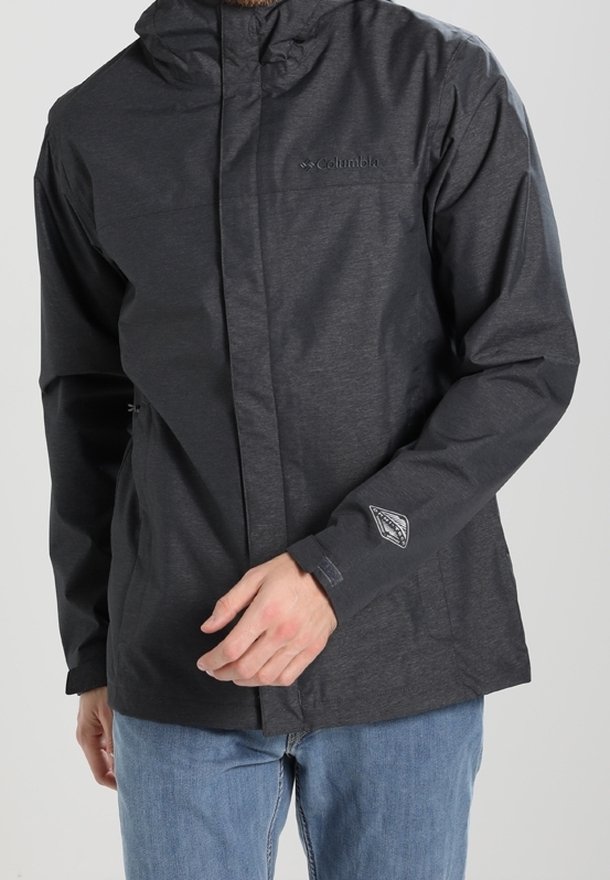 Giacca impermeabile nera con zip frontale, cappuccio regolabile e logo sul petto. Presenta due tasche laterali e una trama sottile.