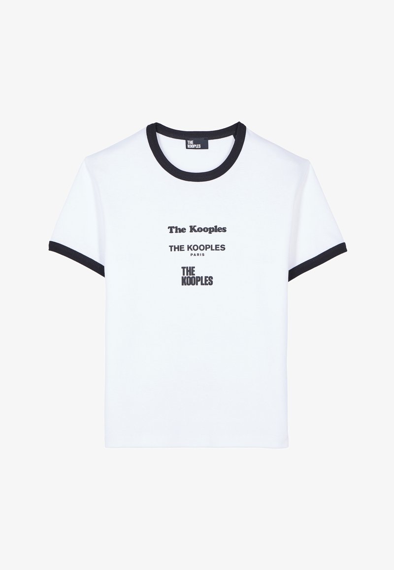 Valkoinen T-paita, jossa on musta ribbaus kauluksessa ja hihoissa. Etupuolella useita erikokoisia mustia printtättyjä logoja "The Kooples".