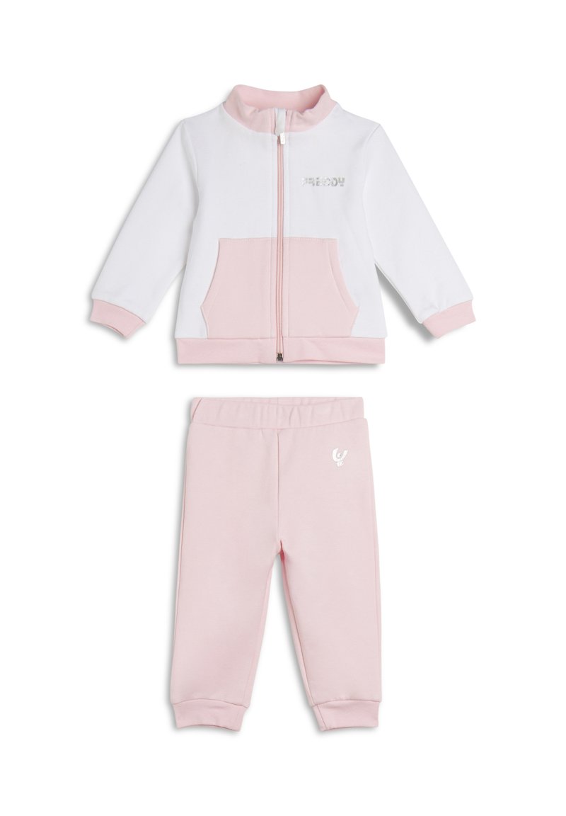 Chándal infantil blanco y rosa que incluye una chaqueta con cremallera y bolsillo frontal, y pantalones a juego con cintura elástica y detalle de logo.