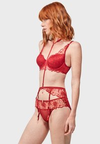 Rode kanten lingerieset met een bralette met bloemendecoratie, een doorschijnende bodysuit en bijpassende panties. Verstelbare bandjes en een delicate uitstraling.