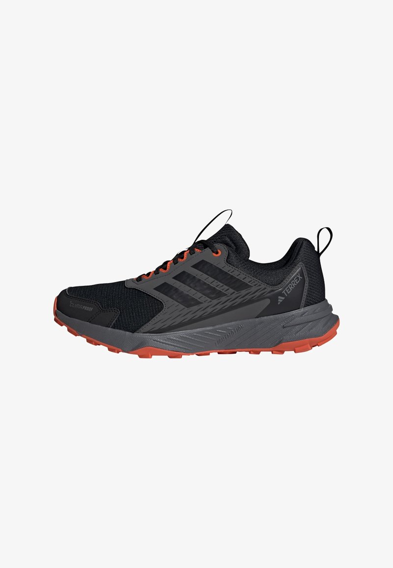 Schwarz-grauer Adidas Terrex Trailrunning-Schuh mit orangefarbener Sohle und Schnürsenkelloch, ausgestattet mit Climaproof- und Lightmotion-Technologie.
