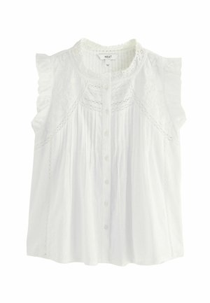 Blusa bianca senza maniche con spalle arricciate, dettagli in pizzo, chiusura a bottoni e pieghe. Realizzata in tessuto leggero.
