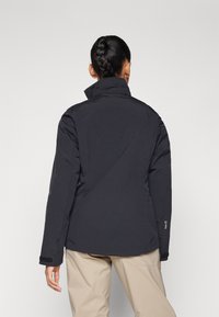 Schwarze wasserdichte Jacke mit hohem Kragen, langen Ärmeln und glatter Oberfläche. Verfügt über eine schmale Passform und dezente Markenkennzeichnung am Ärmel.