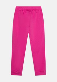 Pantalons extensibles rose fuchsia avec une taille élastique, des jambes fuselées et des poignets côtelés. Texture lisse sans motifs ni embellissements visibles.