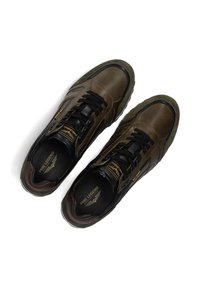 Bruine leren sneakers met textuurpanelen, zwarte veters en groene rubberen zolen. Heeft branding op de tong en binnenin.