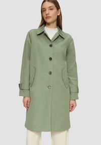 Lichtgroene trenchcoat gemaakt van een gladde, lichte stof met een kraag, knopen aan de voorkant, zijzakken en verstelbare manchetten.
