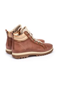 Botas de senderismo de cuero marrón con un acabado texturizado, acentos en beige, ojales de metal y una suela de goma robusta. Presenta un diseño de caña alta.