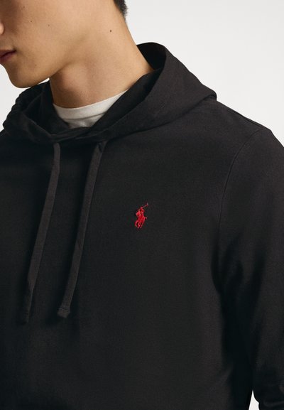 Svart hoodie med framficka av kangurutyp, dragsko i luvan och liten röd broderad logotyp på bröstet. Material av bomullsblandning.