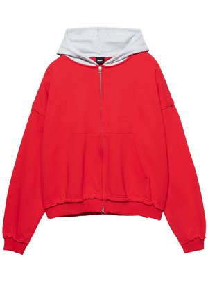 Felpa con zip rossa con cappuccio foderato in grigio, design oversize, grande tasca frontale e orlo e polsini a costine. Tessuto morbido.