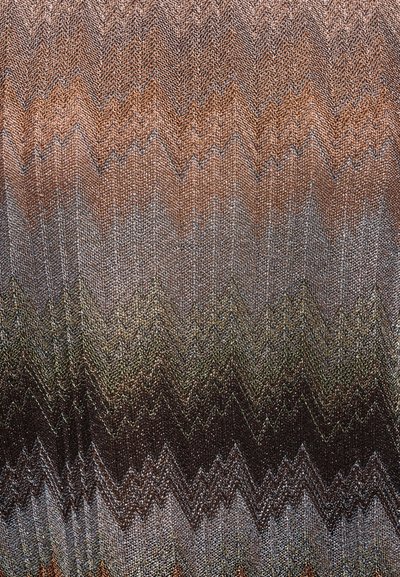 Vzor pleteniny ve tvaru cikcak s střídavými chevronovými pruhy v odstínech hnědé, šedé, olivové a černé, vytvářející texturovaný gradientní efekt.