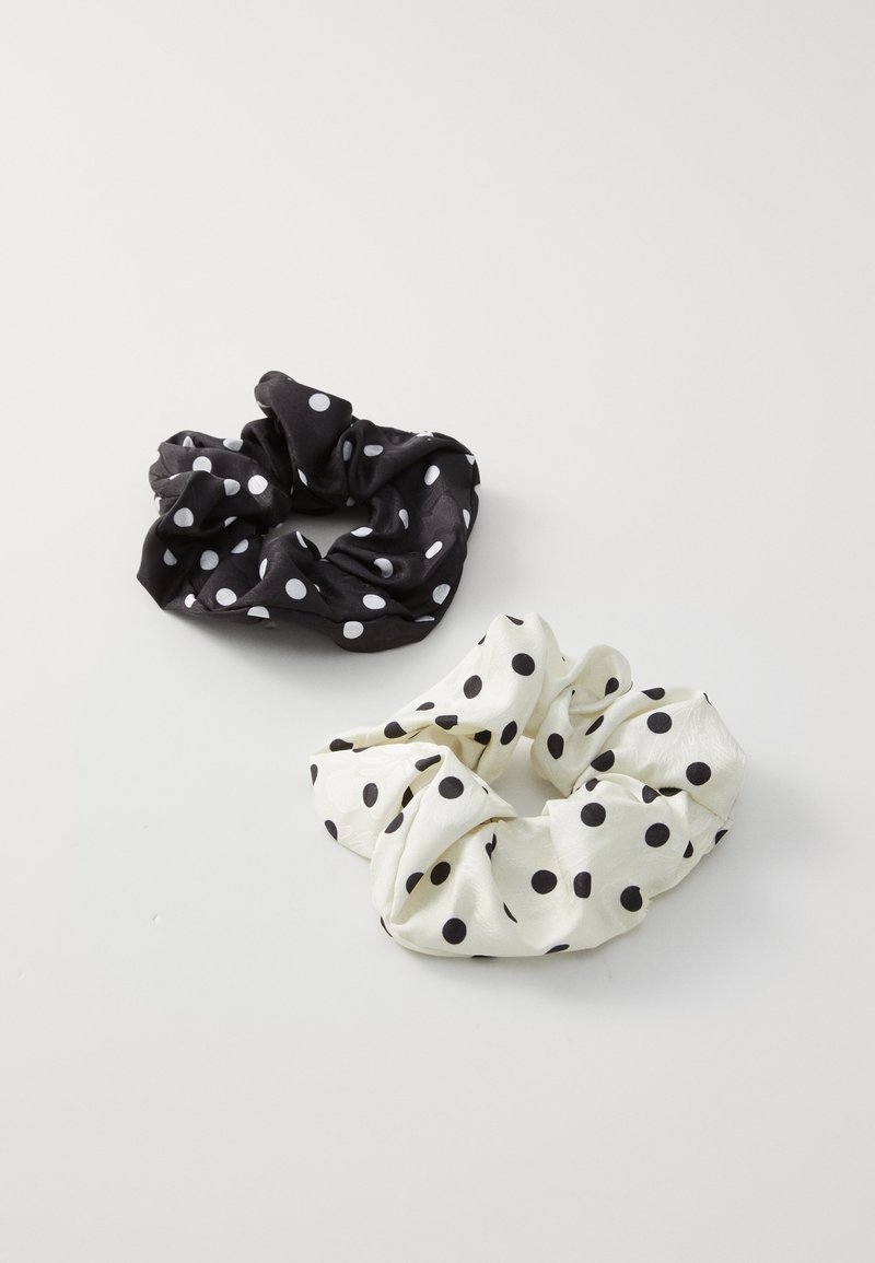 Scrunchies bianchi e neri a pois realizzati in morbido tessuto, caratterizzati da grandi pois distinti e un design a gathered texturizzato.