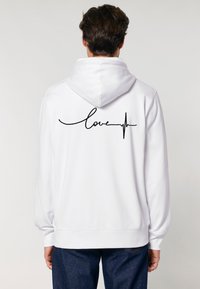 Felpa bianca con cappuccio caratterizzata da una scritta nera che dice "love" accompagnata da una linea del battito cardiaco sul retro. Tessuto misto cotone, vestibilità rilassata.