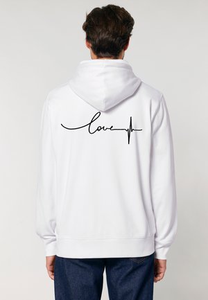Sweatshirt blanc avec un design en script noir portant le mot "amour" et une ligne de battement de cœur au dos. Tissu en mélange de coton, coupe décontractée.