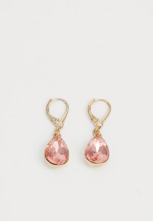 Boucles d’oreilles en or à fermoir lever-back avec des pierres précieuses roses facettées en forme de goutte d’eau, placées en bas sur un fond blanc.