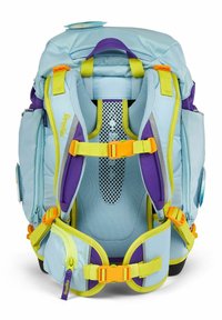Zaino azzurro chiaro con accenti viola e gialli. Presenta spallacci imbottiti, retro in rete, molteplici scomparti e dettagli di hardware vivi.