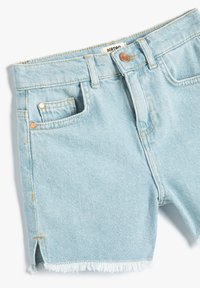 Lysblå denimshorts med en frynset kant, forlommer og guldfarvede detaljer. Fremstillet af bomuldsstof med en blød tekstur.