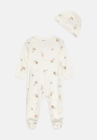 Kreemivärvi beebi kaherihmaline riidekomplekt, millel on pikad varrukad ja jalad, kaetud looma ja looduse elementide korduva mustriga. Kompletis on ka sobiv müts.