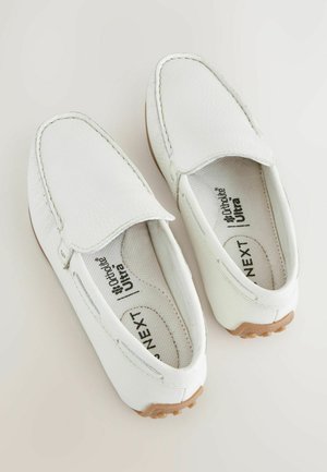 Vita slip-on skor i texturerat läder, med rund tå och minimalistisk sömnad. Innersulan har tryckt varumärke.