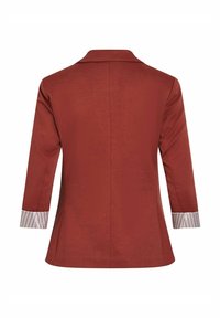 Blazer couleur rouille à manches trois-quarts et poignets blancs avec fines rayures verticales, vu de dos.