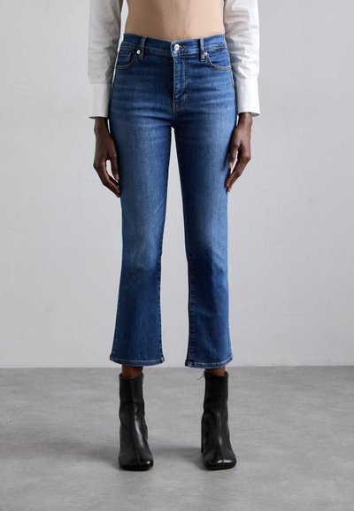 Mellemhøje blå denim jeans med en tætsiddende pasform, cropped flared ben og en rå kant. Har diskret søm og en knaplukning.