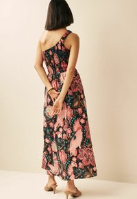 Robe maxi en tissu noir avec des motifs floraux vifs en rose et turquoise. Design une épaule avec un smocké froncé au niveau du buste.