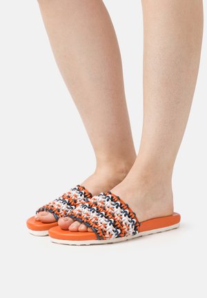 Chanclas naranjas y blancas con parte superior trenzada, que cuentan con un patrón texturizado y una suela plana de goma.