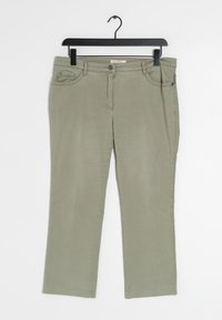 Pantalones de algodón verde oliva con diseño de pierna recta, que cuentan con bolsillos frontales, cremallera y cierre de botón metálico. Cuelga de un gancho negro.