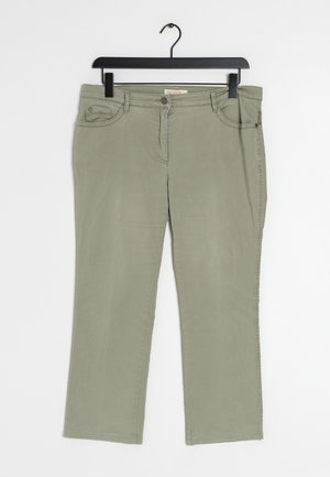Pantalones de algodón verde oliva con diseño de pierna recta, que cuentan con bolsillos frontales, cremallera y cierre de botón metálico. Cuelga de un gancho negro.