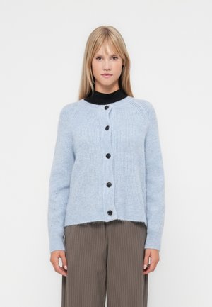 Cardigan bleu clair en tissu doux, avec un col rond et six boutons foncés sur le devant, avec un ourlet légèrement court.