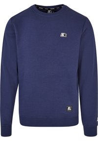 Sudadera de cuello redondo azul marino con mangas largas, pequeño logo blanco en el pecho y etiqueta negra cerca del dobladillo en el lado derecho frontal.