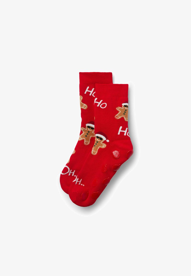 Chaussettes rouges ornées de motifs de bonshommes en pain d'épice et du texte « Ho Ho ». Semelles avec grips texturés pour la traction. Matière en mélange de coton.