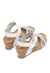 Witte wedge sandalen met gekruiste banden, een gestructureerde kurken zool en een metallic gespaccent. Glad leer en een gevoerd voetbed.