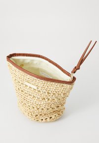 Woven strawveske med buet topp, brun lærglidelås og kremfarget foring med et innvendig merke. Teksturert, lett design.