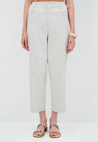 Lichtgrijze broek met wijde pijpen en een hoge taille, zijzakken en omgeslagen zoom. Gemaakt van een soepele stof en voorzien van een knoopsluiting.