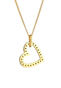 Pendente a forma di cuore in oro su una catena, caratterizzato da motivi a intaglio e a punti, superficie liscia e finitura lucida. La catena è semplice e delicata.