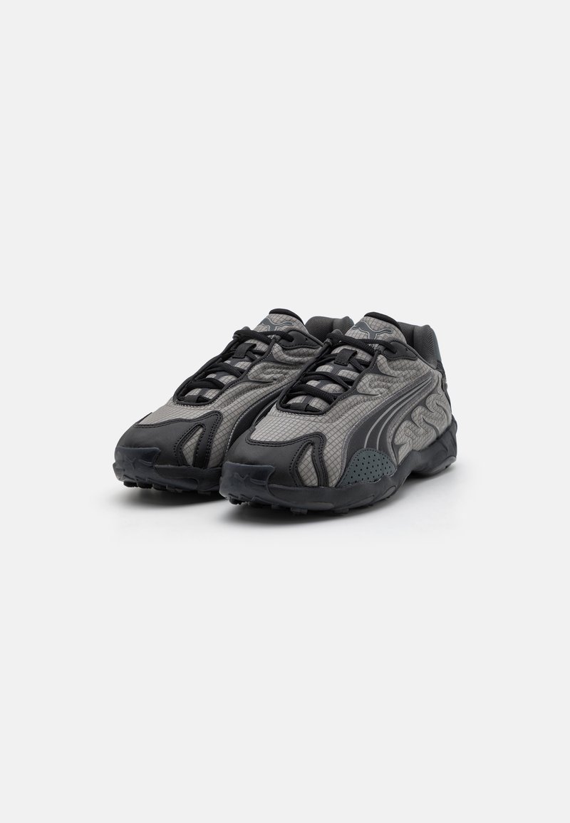 Graue Freizeitsneaker mit strukturierten Mesh-Einsätzen, schwarzen Akzenten und einer dicken Gummisohle. Verfügt über ein Schnürdesign und eine abgerundete Zehenpartie.