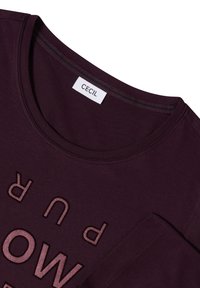 T-shirt in cotone color bordeaux con collo rotondo, caratterizzata da scritte testurizzate in bordeaux "PUR" e "LOW" in una finitura lucida a contrasto.
