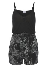 Zwart mouwloos topje met knoopsluiting, gedragen met zwarte shorts met witte paisleypatronen en een gestrikt riem in de taille.